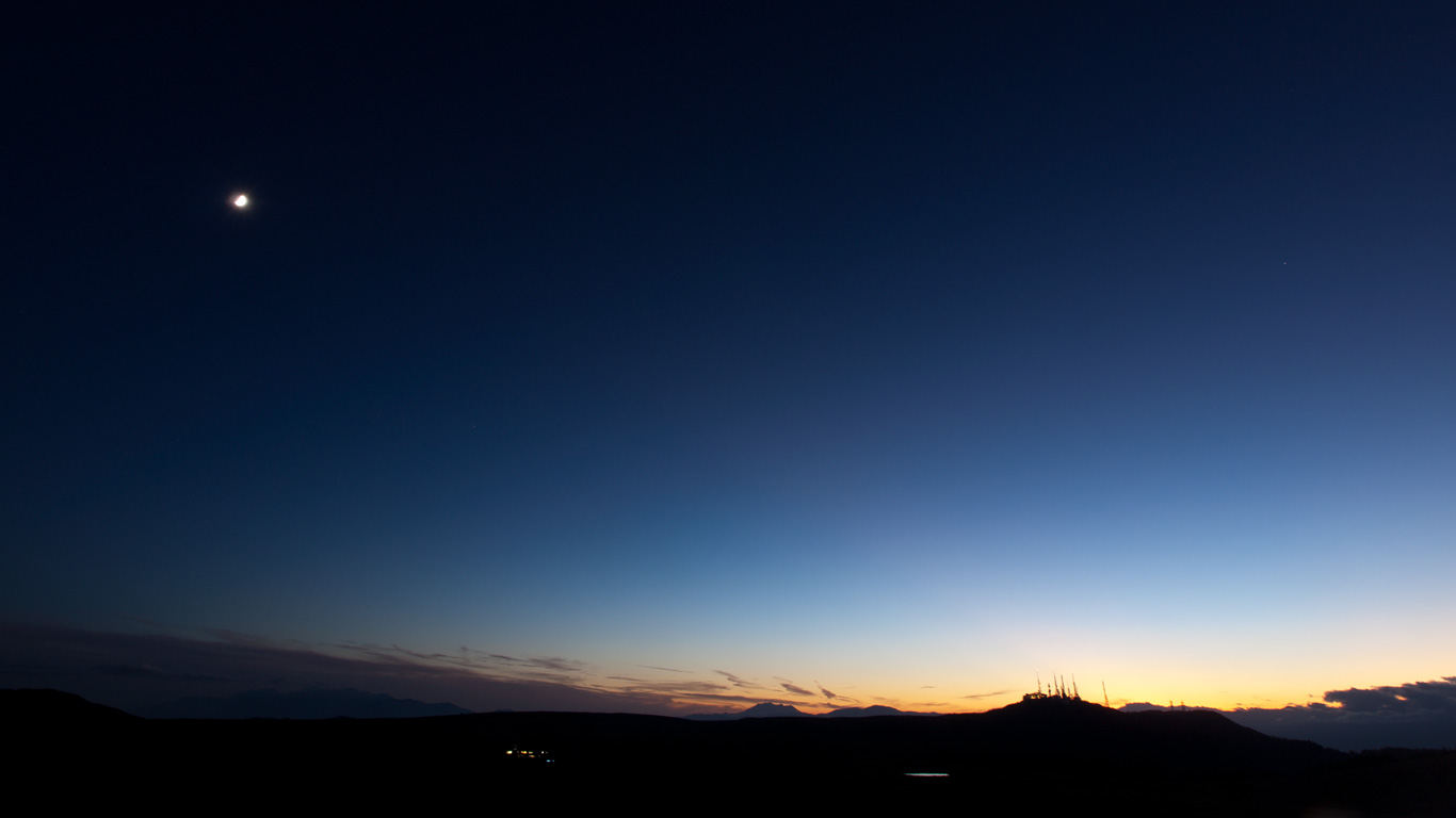 高原の夕暮れと月